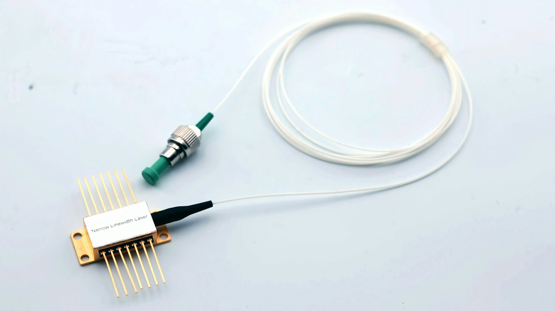 A fiber-coupled narrow-linewidth laser module with gold pins and an FC/APC connector